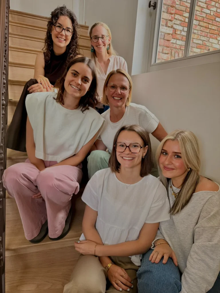 Het team van Praktijk het Centrum zittend op de trap